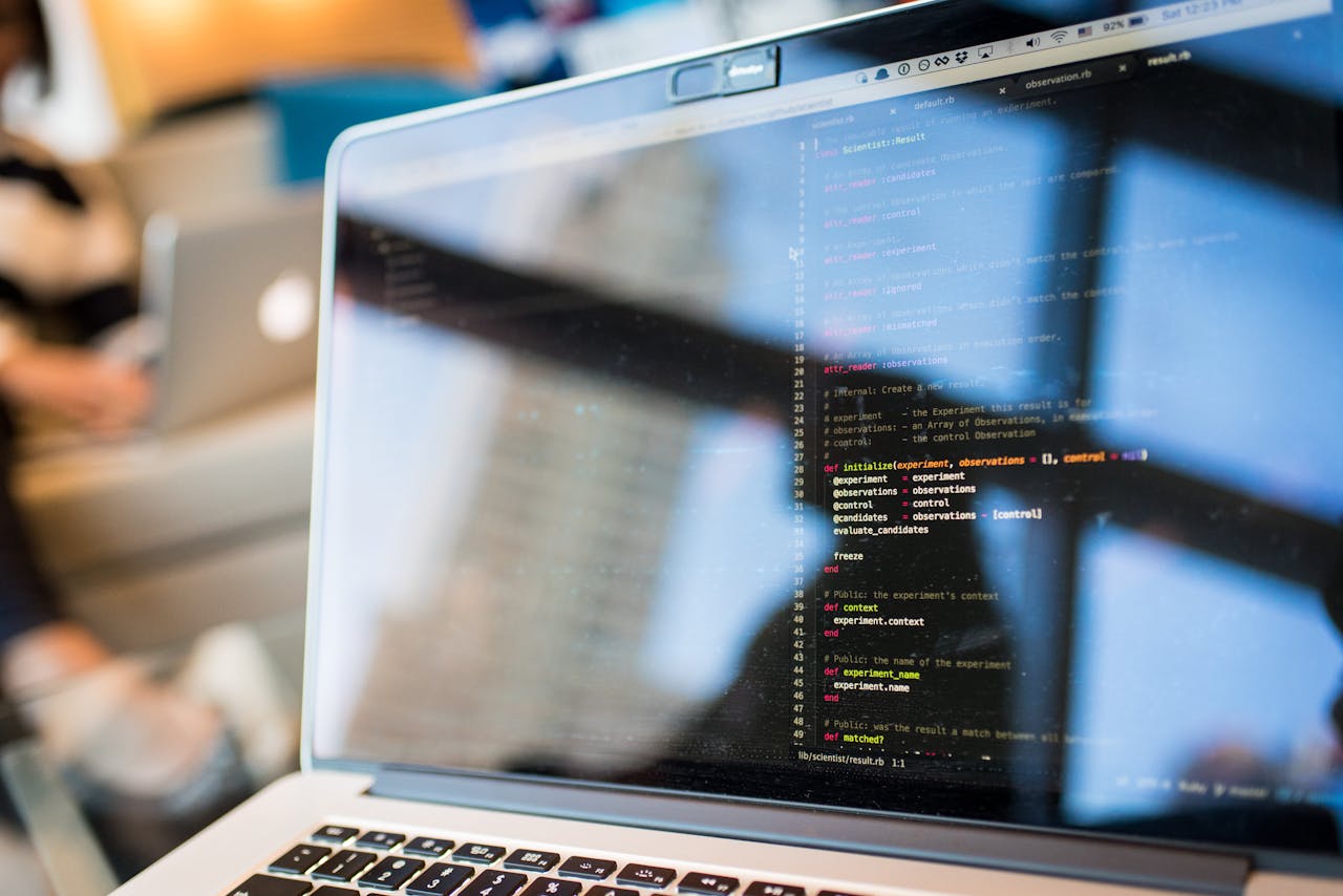 who-we-are Laptop displaying code with reflection, perfect for tech and programming themes.