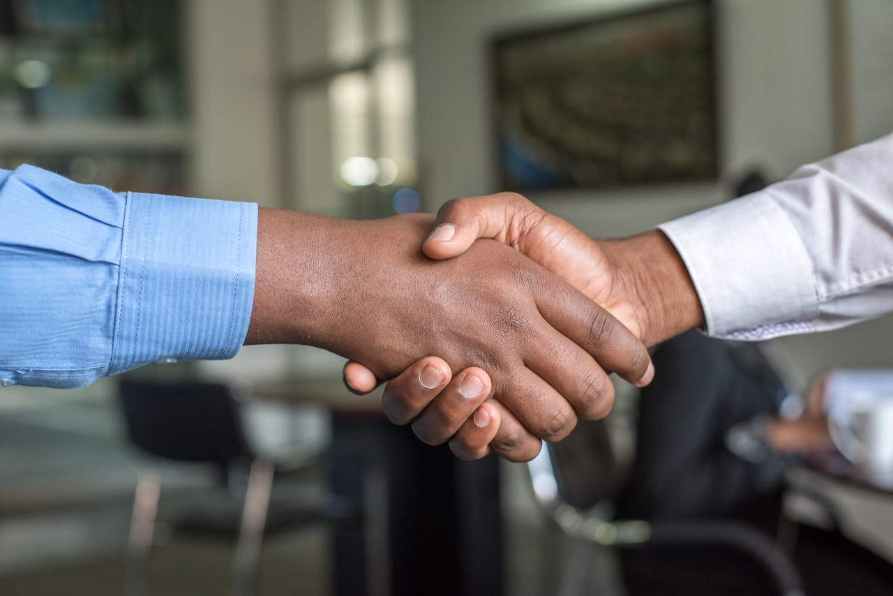 about-bg Close-up of two men's handshake symbolizing agreement in an office.